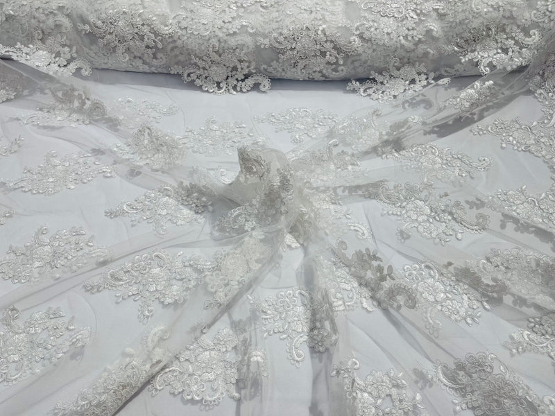 White floral design embroidery on a mesh lace with sequins and cord-sold by the yard.