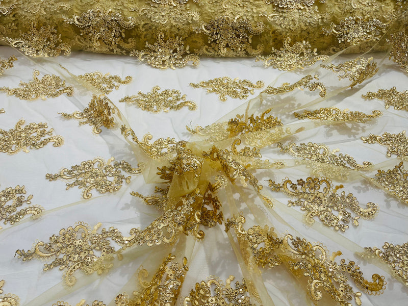 Gold metallic floral design embroidery on a mesh lace with sequins and cord-sold by the yard.