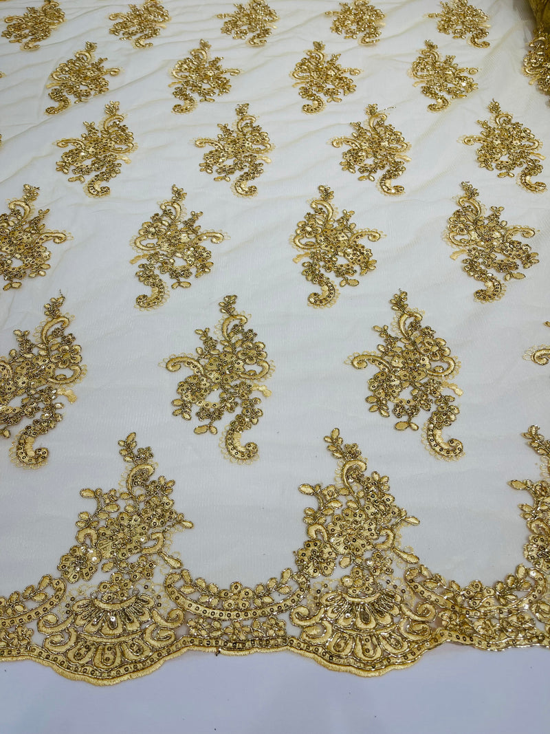 Gold metallic floral design embroidery on a mesh lace with sequins and cord-sold by the yard.